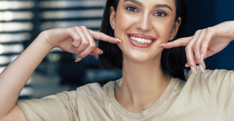 woman smiling and pointing to her teeth