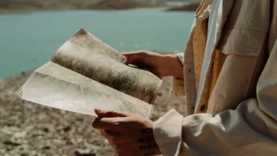 A traveler holding a map beside a lakeK